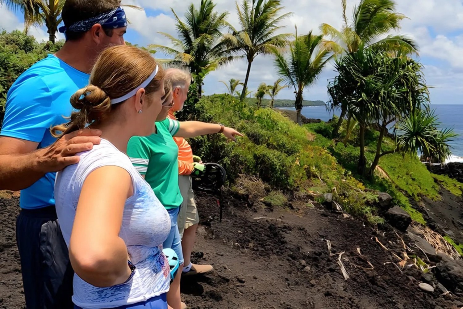 Group of people on a cliff with palm trees, overlooking the ocean on a sunny day.